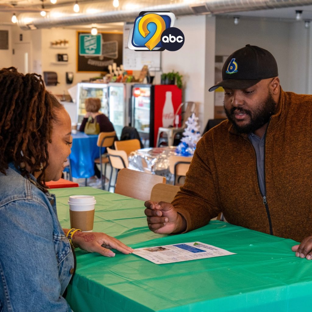 Maurice Davis, Director of South of 6 Business District, reviewing the Johnson County Underestimated Small Business Grant application with someone. KCRG-TV logo at top